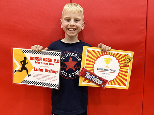 Luke holding up his Most Laps Run awards for the Dassa Dash 2.0