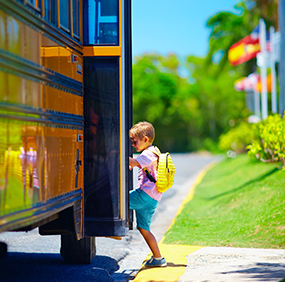 Male student getting onto a school bus