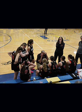 Coach talking to team on the court