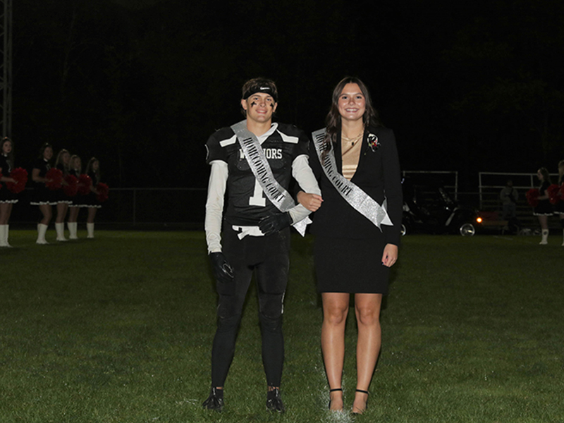 Homecoming couple wearing banners