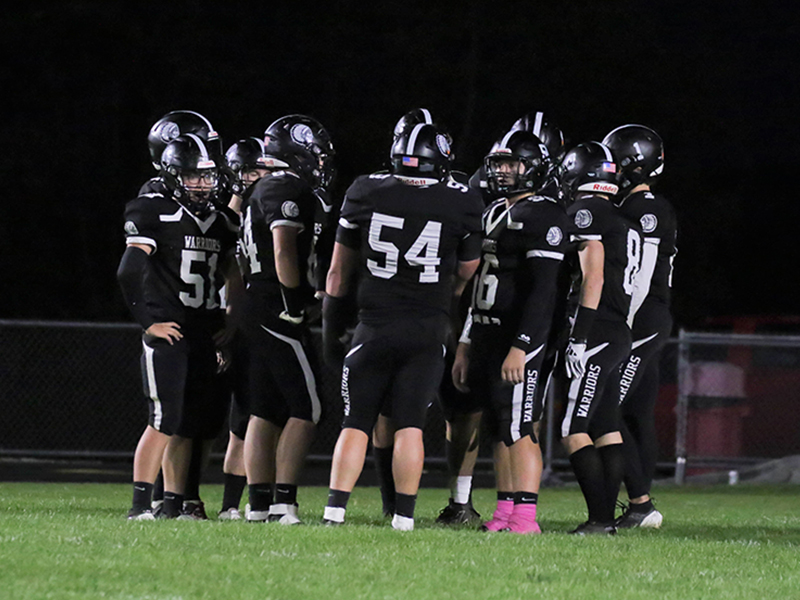 Football players in a huddle on the field