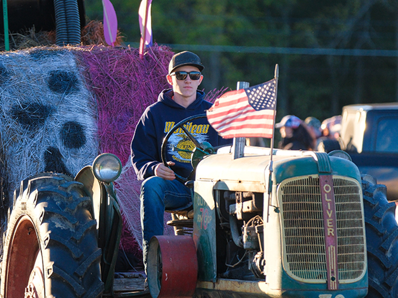 Student on a tractor with USA flag