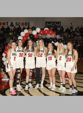 Senior girls basketball team under balloons